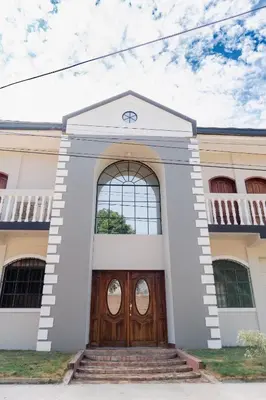 a white building with a wooden door and stairs at Casa Familiar con Piscina y Aire Acondicionado Concepción Batres in Concepción Batres