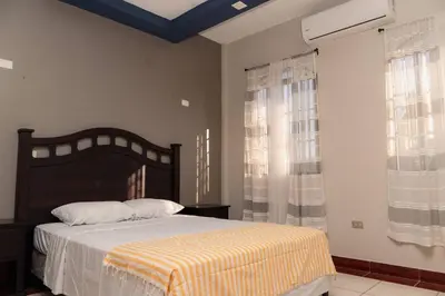 a bedroom with a bed and a large window at Casa Familiar con Piscina y Aire Acondicionado Concepción Batres in Concepción Batres