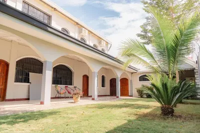 a palm tree sits in front of a building at Casa Familiar con Piscina y Aire Acondicionado Concepción Batres in Concepción Batres