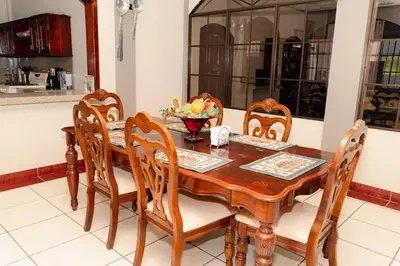 a wooden table with chairs and a bowl of fruit on it at Casa Familiar con Piscina y Aire Acondicionado Concepción Batres in Concepción Batres