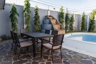 a table and chairs next to a swimming pool at Casa Familiar con Piscina y Aire Acondicionado Concepción Batres in Concepción Batres
