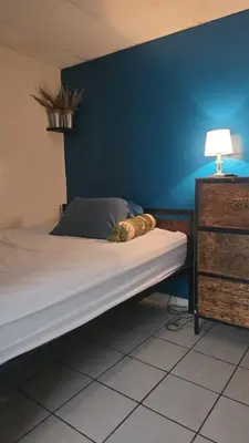 a bed in a bedroom with a blue wall at casa de elena in Santa Ana