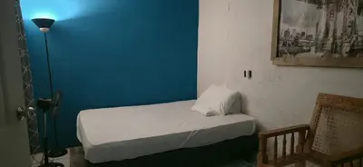 a small bed in a room with a blue wall at casa de elena in Santa Ana