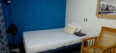 a room with a bed with a blue wall at casa de elena in Santa Ana