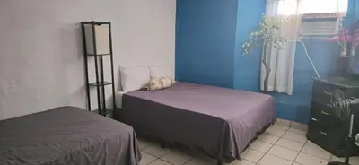 a bedroom with two beds and a blue wall at casa de elena in Santa Ana