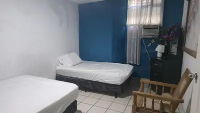 a room with two beds and a blue wall at casa de elena in Santa Ana