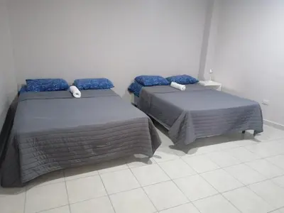 two beds sitting next to each other in a room at Apartamento familiar 1 con 3 habitaciones y 4 camas in San Salvador