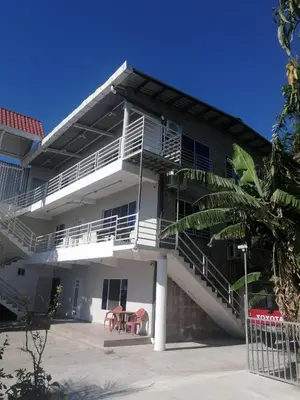 a white building with a balcony and a table at Apartamento familiar 1 con 3 habitaciones y 4 camas in San Salvador