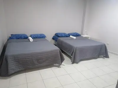 two beds sitting next to each other in a room at Apartamento familiar 1 con 3 habitaciones y 4 camas in San Salvador