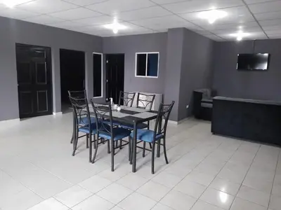 a dining room with a black table and blue chairs at Apartamento familiar 1 con 3 habitaciones y 4 camas in San Salvador