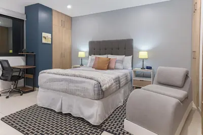 a bedroom with a bed and a desk and a chair at Silvertop - A magical apartment with great view in San Salvador
