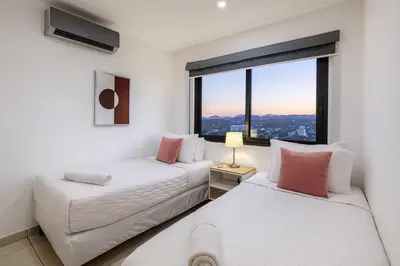 two beds in a room with a large window at Silvertop - A magical apartment with great view in San Salvador