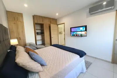 a bedroom with a bed and a couch and a tv at Silvertop - A magical apartment with great view in San Salvador
