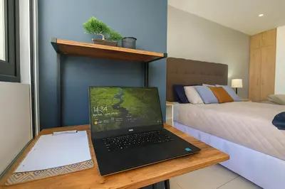 a laptop computer sitting on a desk next to a bed at Silvertop - A magical apartment with great view in San Salvador