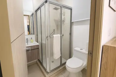 a bathroom with a toilet and a glass shower at Silvertop - A magical apartment with great view in San Salvador