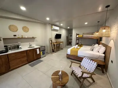 a hotel room with a bed and a kitchen and a room at Litos Hotel in La Libertad