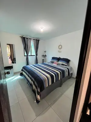 a bedroom with a bed with blue and white sheets at Home Sweet Home at Opico Garden in San Juan Opico