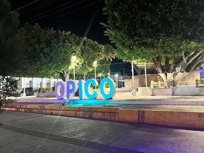a sign that says opico on a bench at night at Home Sweet Home at Opico Garden in San Juan Opico