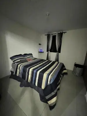 a bedroom with a striped bed in a room at Home Sweet Home at Opico Garden in San Juan Opico