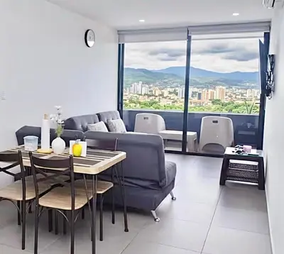 a living room with a couch and a table with a view at Escalon apartment in San Salvador