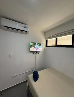 a bedroom with a bed and a tv on the wall at Escalon apartment in San Salvador