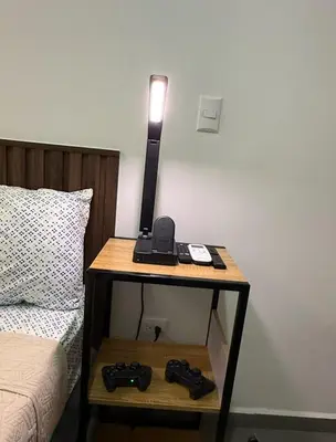 a table with a lamp on it next to a bed at Escalon apartment in San Salvador