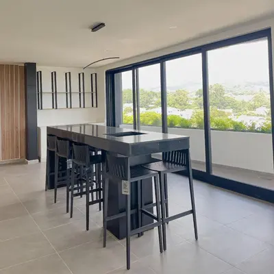 a kitchen with a black table and chairs and windows at Escalon apartment in San Salvador