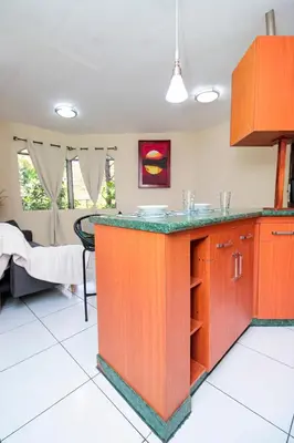 a kitchen with an orange island in a room at Modern Stylish Apt in Secure Area in San Salvador in San Salvador