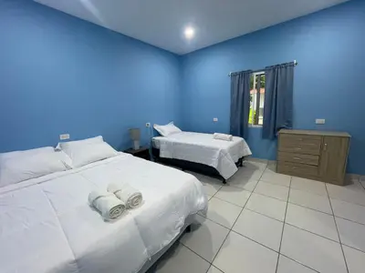 a bedroom with two beds and a blue wall at Lodge Ayla Punta Mango in Jucuarán