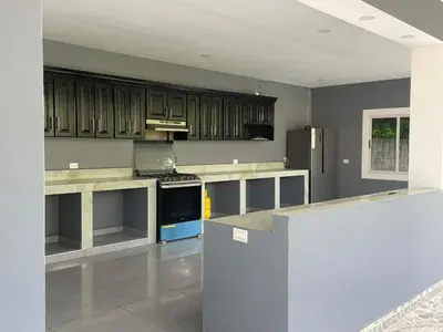 a kitchen with wooden cabinets and a blue stove at Lodge Ayla Punta Mango in Jucuarán