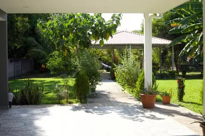 a garden with a white pergola and some plants at Lodge Ayla Punta Mango in Jucuarán