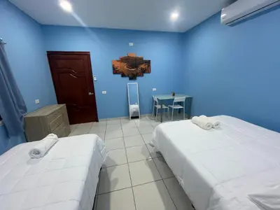 a blue room with two beds and a table at Lodge Ayla Punta Mango in Jucuarán