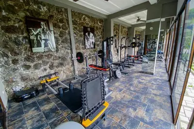 a gym with a row of exercise equipment on the wall at Open space concept that allows for multiple places to hang out in San Salvador