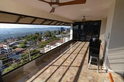 a balcony with a view of a city at Open space concept that allows for multiple places to hang out in San Salvador
