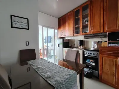 a kitchen with a dining table and a stove at Susana's house, your home in Ahuachapán in Ahuachapán