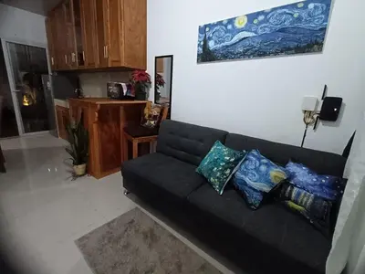 a living room with a black couch with pillows at Susana's house, your home in Ahuachapán in Ahuachapán