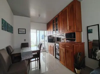 a kitchen with wooden cabinets and a table and a couch at Susana's house, your home in Ahuachapán in Ahuachapán
