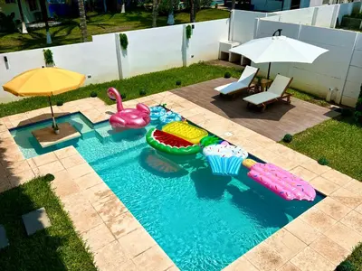 a swimming pool with inflatables and an umbrella at Villa Nakär - Oceanfront Luxury Villa in Playa Amatecampo, El Salvador in La Esmeralda