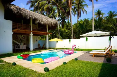 a backyard with a pool with inflatables and a house at Villa Nakär - Oceanfront Luxury Villa in Playa Amatecampo, El Salvador in La Esmeralda