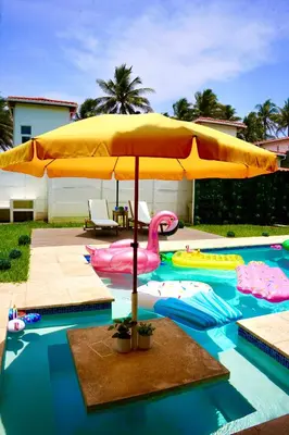 a pool with a pink flamingo and an umbrella at Villa Nakär - Oceanfront Luxury Villa in Playa Amatecampo, El Salvador in La Esmeralda