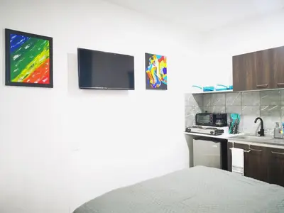 a room with a bed and a kitchen with a tv at Apartamento privado, Miramonte, San Salvador in San Salvador