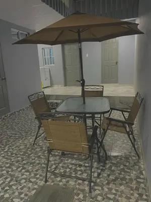 a table and chairs with an umbrella on a patio at Palo Coco Home in Santa Ana