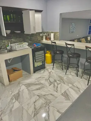 a kitchen with a marble floor with chairs in it at Palo Coco Home in Santa Ana