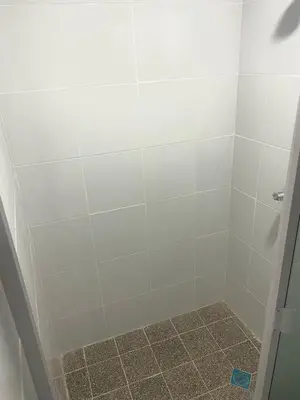 a bathroom with a shower with white tiles at Palo Coco Home in Santa Ana