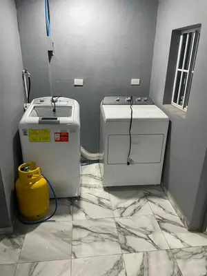 a room with two water heaters on a tile floor at Palo Coco Home in Santa Ana