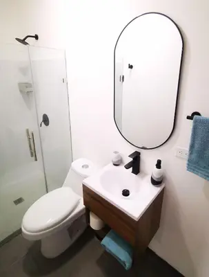 a bathroom with a toilet and a sink and a mirror at Suite privada de 1 habitacion en San Salvador in San Salvador
