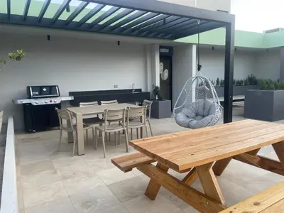 a patio with a table and chairs and a swing at Moderno apart en Col Escalón,vista,piscina,gimnasio in San Salvador