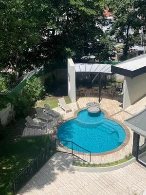 a swimming pool with chairs and an umbrella at Moderno apart en Col Escalón,vista,piscina,gimnasio in San Salvador