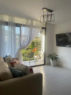 a living room with a couch and a large window at Moderno apart en Col Escalón,vista,piscina,gimnasio in San Salvador