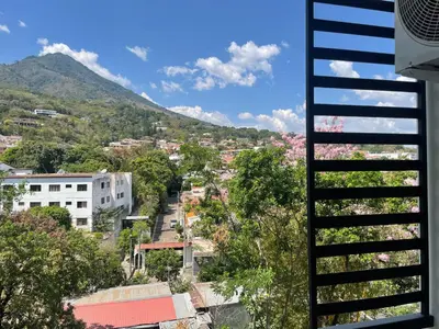 a view of a city with trees and a mountain at Moderno apart en Col Escalón,vista,piscina,gimnasio in San Salvador